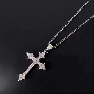 Detailed close-up of a silver cross necklace with pavé-set shimmering cubic zirconia