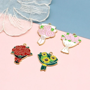 Set of four colorful enamel flower charms featuring roses and sunflowers on a pink background