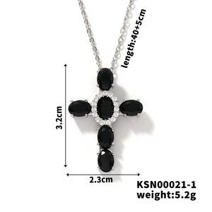 Detail view of silver cross pendant with black oval stones and micro-pave zircon crystals
