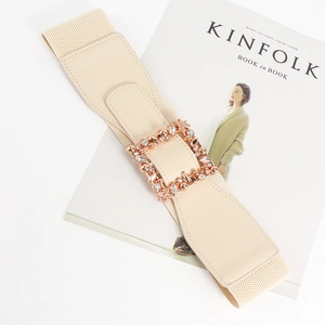 Detail of wide elastic waist belt with rose gold rhinestone floral buckle on magazine