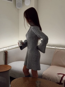 Detail of grey ribbed knit dress featuring elegant flare sleeves and slim fit silhouette