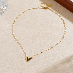Gold plated stainless steel necklace with black heart pendant and white enamel beads