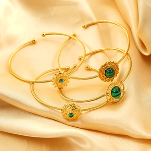 Set of four gold steel wire bangles with evil eye and malachite on champagne silk