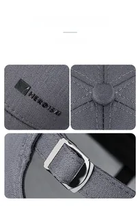 Detail of grey baseball cap showing twill fabric, HEROISM logo and adjustable metal buckle