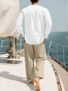Herren Set aus Baumwolle und Leinen mit weißem Hemd und beiger Hose auf einem Bootsdeck
