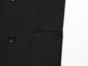 Detailed macro view of black resin buttons and fine twill fabric texture on pants