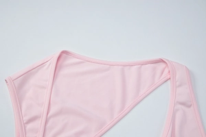 Detailed close-up of pink irregular neckline stitching on slim fit summer tank top