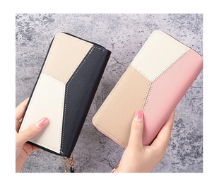 Detail of multi-color geometric patchwork on long zipper wallet with wrist strap