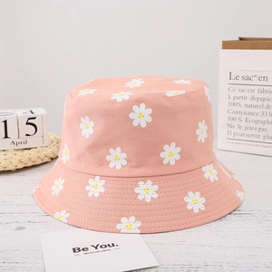 Close-up of pink bucket hat with daisy print on soft wooden texture background