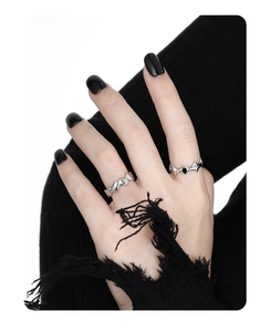 Gothic style irregular geometric thorn rings on fingers with black nails and knitwear