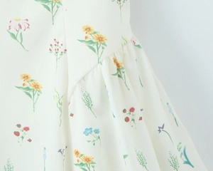 Makrodetail von Chiffonstoff mit Blumenmuster, feiner Smok-Textur und sauberen Nähten