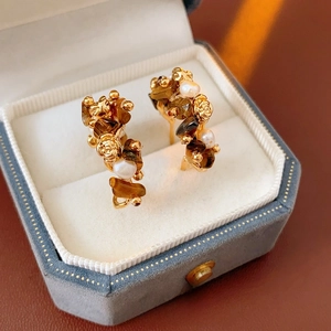 Vintage golden C-shaped hoop earrings with tiger eye stone and pearl flower details