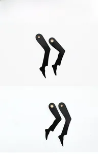 Close-up of matte black L-shaped clock hands with hexagonal holes for clock movement