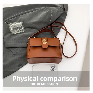 Brown leather handbag detail featuring a golden metal twist lock and a sleek top handle