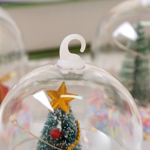 Macro shot of a Christmas hanging ball with a mini tree and gold star details