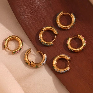 Detail of 18K gold-plated earrings with colorful enamel floral patterns on silk surface