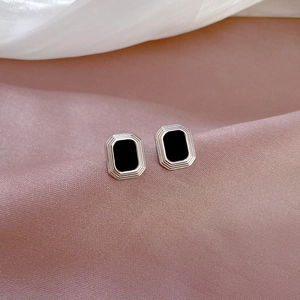 Macro view of square minimalist titanium steel earrings with black and silver texture