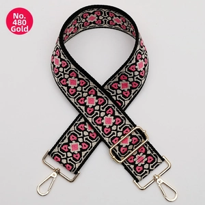 Close-up of ethnic geometric embroidered bag strap with gold metal lobster clasps