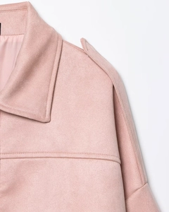 Detalle de chaqueta rosa de ante con cuello de solapa y costuras en las charreteras