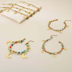 Detailed macro view of layered beaded bracelet with golden moon and heart charms