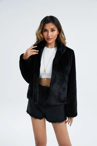 Détail d'une veste noire en fausse fourrure de lapin avec col montant et texture douce