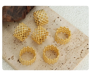 Set of 6 gold lattice rings with embedded crystals on a natural stone background