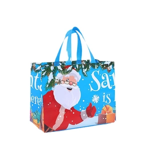Blue Christmas non-woven gift bag with Santa Claus, snowflakes, and sturdy blue handles