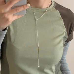 Mirror selfie showing the silver Y-shaped adjustable long necklace on a female model