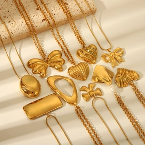 Flat lay of multiple gold titanium steel necklaces with heart and butterfly pendants