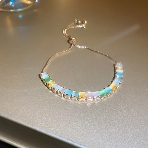 Detail of adjustable gold bolo bracelet with rectangular multicolored gemstones