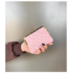 Pink quilted coin purse with gold frame and bead clasp held in hand for size display