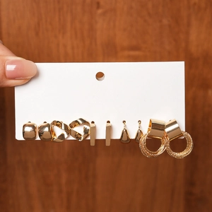 Close-up of a 6-pair set of geometric gold earrings with square and hoop designs