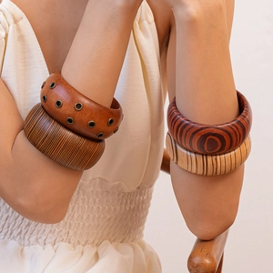 Close-up of vintage wide wooden bracelets with natural grain and rivet details on model