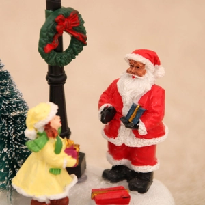 Detailed Christmas miniature scene with Santa Claus, girl, lamp post and festive tree