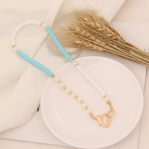 Detail of blue and white clay bead necklace with pearls and gold heart lobster clasp