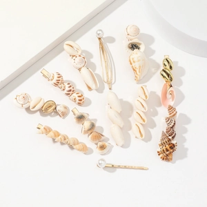 Natural seashell and pearl hair clip set with gold metal bases on white background
