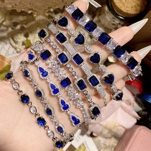 Macro shot showing blue spinel and zircon gemstones set in various luxury silver bracelet styles