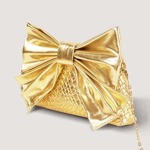 Detail of gold bow evening bag featuring snake-embossed texture and sleek metal chain