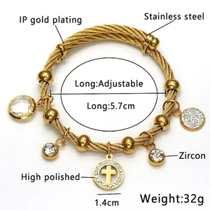 Macro detail of 18K gold plated stainless steel cable bracelet with zircon cross charm