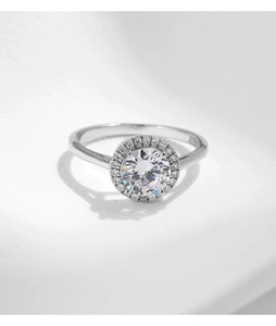 Macro shot of silver halo ring featuring a large faceted gemstone with sparkling diamonds