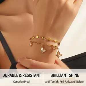 Detail view of double-layer gold heart chain bracelet with butterfly charms and crystals