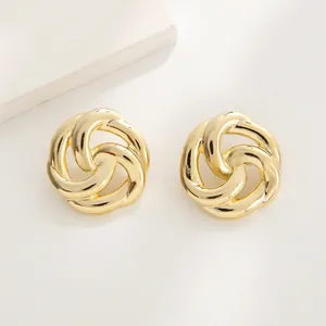 Macro detail of gold-plated knot earrings with a polished finish and vintage twist design