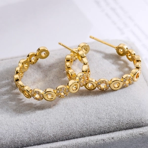 Elegante goldene C-Ohrringe mit Zirkonia-Inlay in einer weichen Samt-Schmuckschatulle