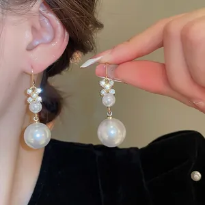 Eleganti orecchini a goccia d'oro con fiore di diamante e doppie perle da donna