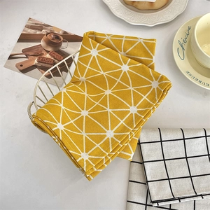 Detail of yellow cotton linen star pattern placemat folded in a wire basket