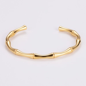 Detailed close-up of a polished golden bamboo joint cuff bangle from a 45-degree angle