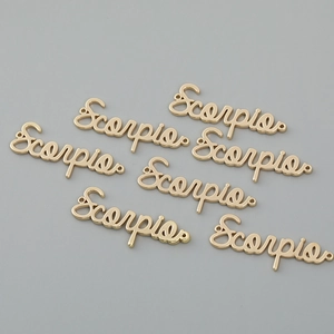 Macro detail of gold Scorpio letter charms for DIY necklace and bracelet crafting