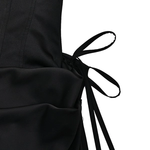 Close-up of sleek black satin dress side lacing detail with elegant ribbon ties