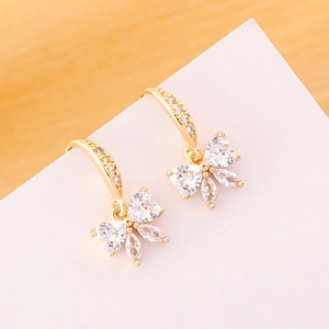 Detailed close-up of golden butterfly earrings with sparkling white cubic zirconia crystals
