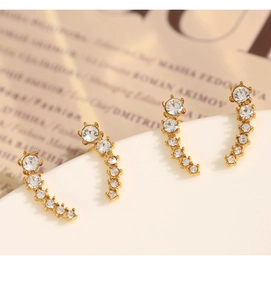 Macro detail of gold half-moon earrings with gradient white cubic zirconia stones